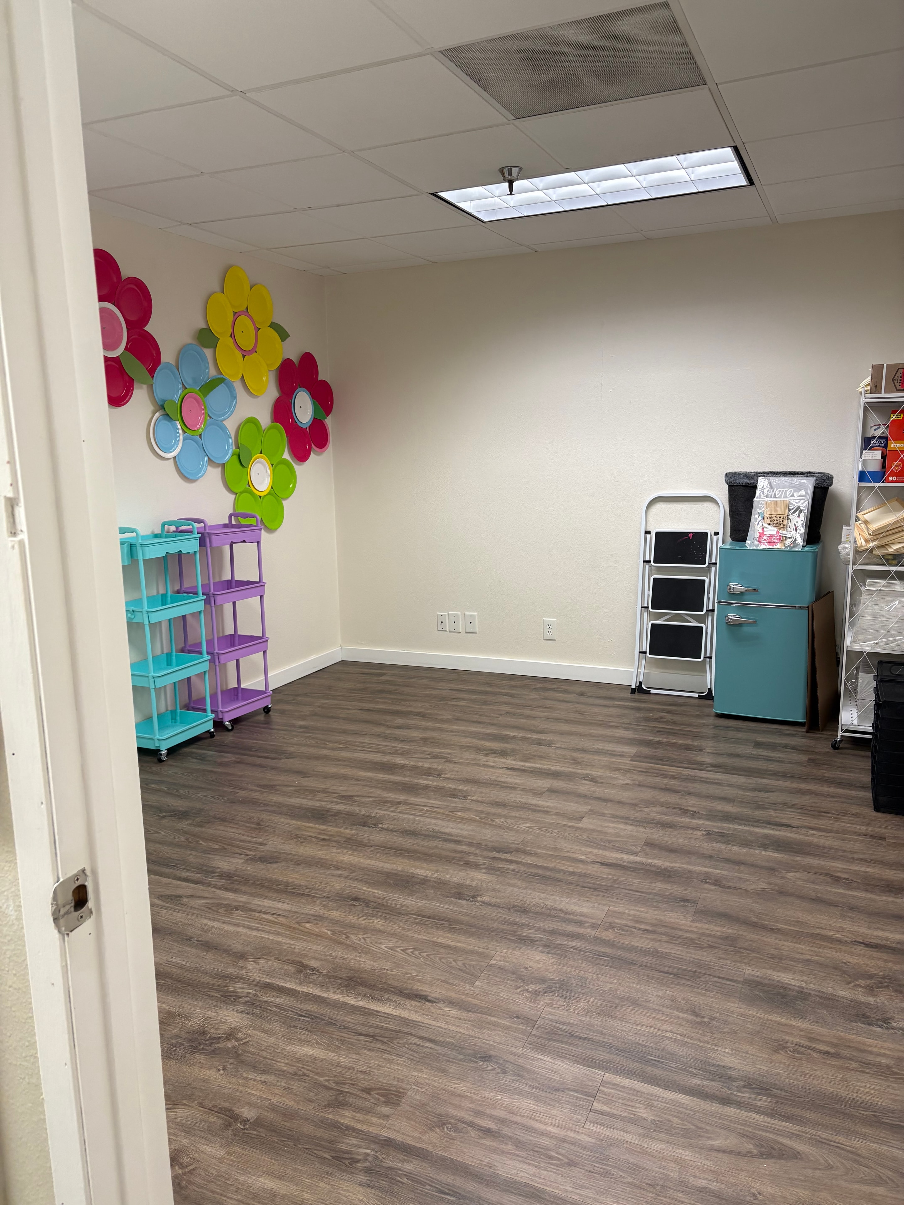 Studio storage room with colorful flower decorations and teal cabinets